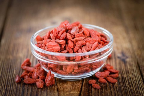 Goji Berries (dried) on an old wooden table as detailed close-up shot (selective focus)