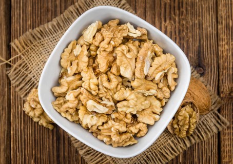 Walnuts (kernels) on an old wooden table as detailed close-up shot (selective focus)
