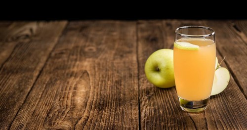 Apple Juice on a vintage background as detailed close-up shot (selective focus)