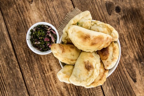 Portion of healthy Empanadas on an old wooden table (selective focus, close-up shot)