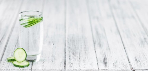 Cucumber Water on rustic wooden background as close-up shot