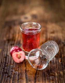 Cherry Liqueur as high detailed close-up shot on a vintage wooden table, selective focus