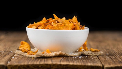 Sweet Potato Chips on an old wooden table as detailed close-up shot, selective focus