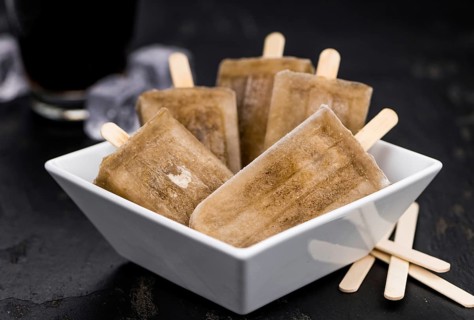 Slate slab with cola popsicles (homemade) as detailed close-up shot (selective focus)