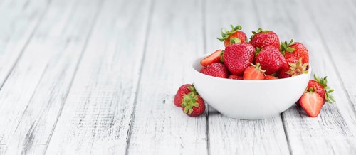 Strawberries as high detailed close-up shot on a vintage wooden table, selective focus