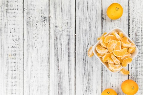Raw Tangerine pieces (close-up shot) on vintage background