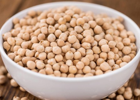 Dried Chickpeas as high detailed close-up shot on a vintage wooden table, selective focus