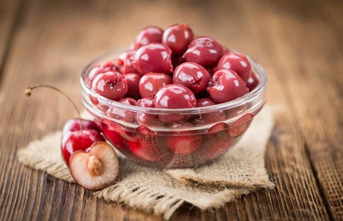 Preserved Cherries on an old wooden table as detailed close-up shot, selective focus