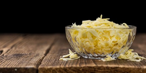 Old wooden table with grated Cheese (close-up shot)