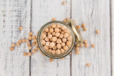 Dried Chickpeas as high detailed close-up shot on a vintage wooden table, selective focus