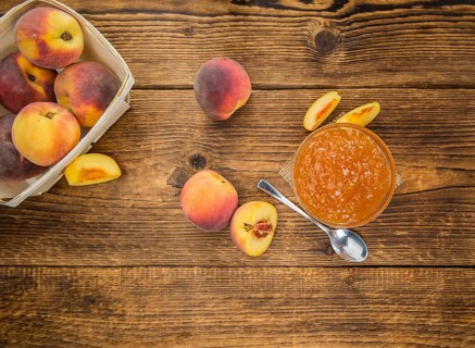 Peach Jam on an old wooden table as detailed close-up shot, selective focus