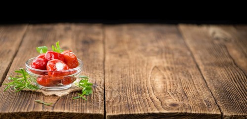 Fresh made Red Pepper (stuffed with cheese) on an old and rustic wooden table (selective focus,