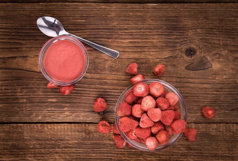 Strawberry powder as high detailed close-up shot on a vintage wooden table, selective focus