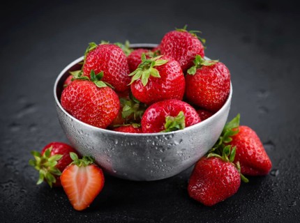 Portion of Strawberries as detailed close up shot on a slate slab, selective focus