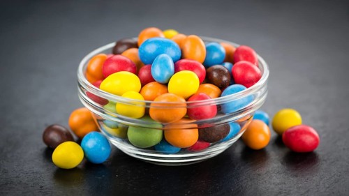 Portion of Cocolate coated Peanuts on a rustic slate slab (selective focus, close-up shot)