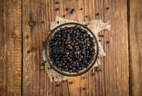 Black Peppercorns preserved on wooden background, selective focus, close-up shot