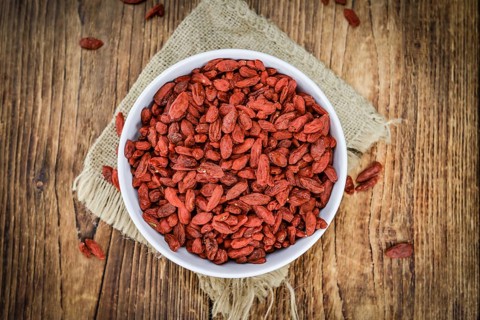 Goji Berries (dried) on an old wooden table as detailed close-up shot (selective focus)