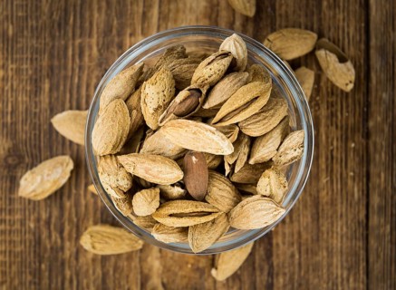 Roasted and salted Almonds (with shell) on a vintage background (close-up shot)