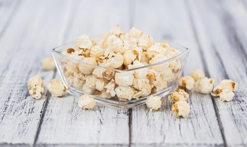 Fresh made Popcorn on an old and rustic wooden table, selective focus, close-up shot