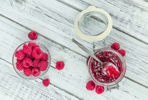 Fresh made Raspberry Jam on an old and rustic wooden table, selective focus, close-up shot