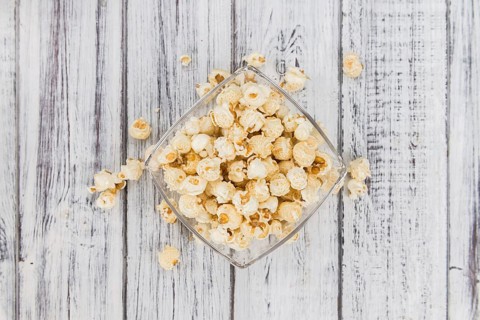 Fresh made Popcorn on a vintage background as detailed close-up shot