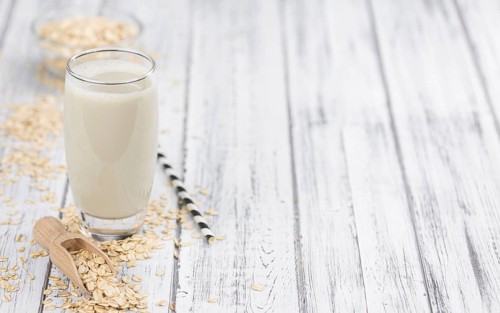 Healthy Oat Milk on a wooden table as detailed close-up shot (selective focus)