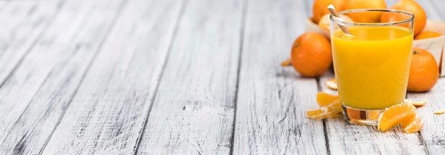 Homemade Tangerine Juice on an old and rustic wooden table (selective focus, close-up shot)