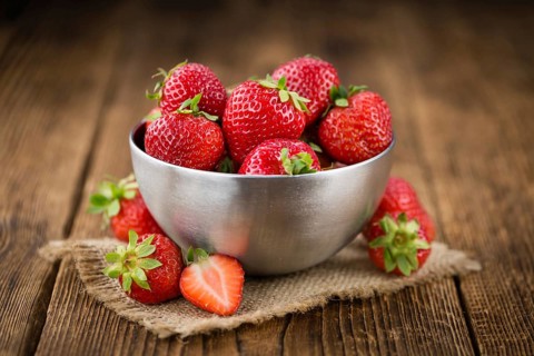 Strawberries on an old wooden table as detailed close-up shot, selective focus