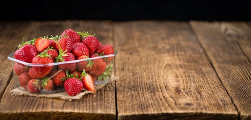 Strawberries on an old wooden table as detailed close-up shot, selective focus