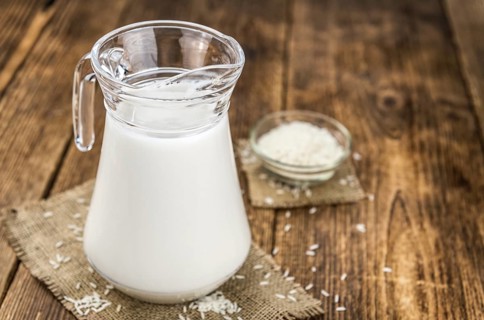 Wooden table with Rice Milk (detailed close-up shot, selective focus)