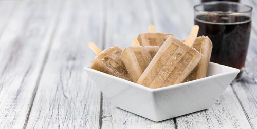 Fresh made Cola Popsicles on wooden background (selective focus, close-up shot)