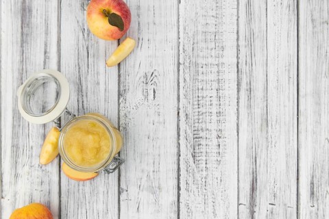 Old wooden table with fresh made Applesauce (selective focus, close-up shot)
