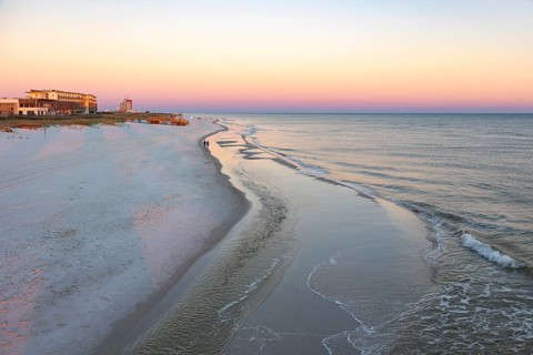 Tow women walking along the Gulf of Mexico beach as the sun rises over the Gulf of Mexico at Gulf