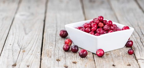 Vintage wooden table with Cranberries (preserved) (selective focus, close-up shot)