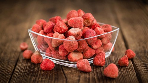 Dried Strawberries on rustic wooden background as close-up shot