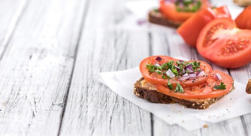 Portion of healthy Tomato Sandwich on an old wooden table (selective focus, close-up shot)