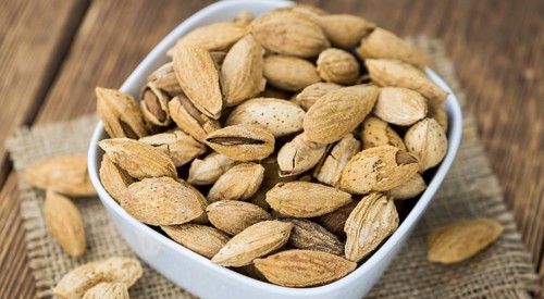 Roasted and salted Almonds (with shell) on a vintage background (close-up shot)
