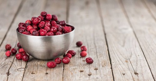 Dried Cranberries on an old wooden table (selective focus)