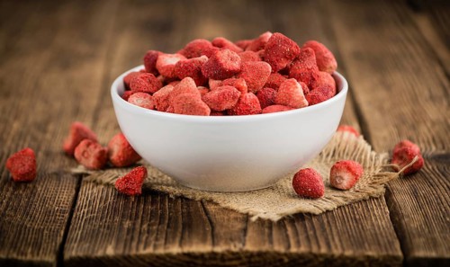 Strawberries (dried) as high detailed close-up shot on a vintage wooden table, selective focus