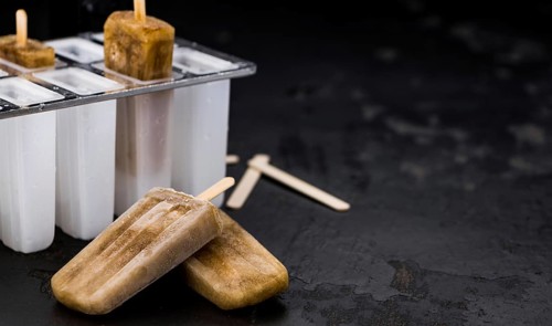 Some homemade Cola Popsicles (close-up shot, selective focus) on vintage background