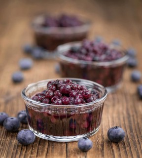 Homemade Preserved Blueberries on an wooden table as detailed close-up shot, selective focus
