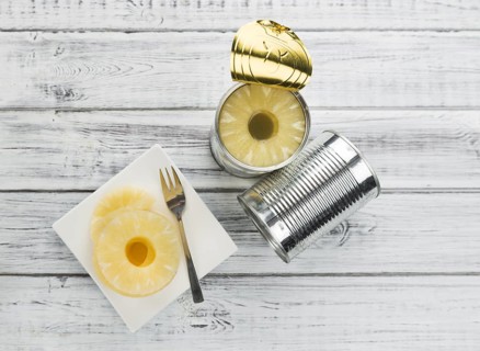 Preserved Pineapple Rings as high detailed close-up shot on a vintage wooden table, selective focus