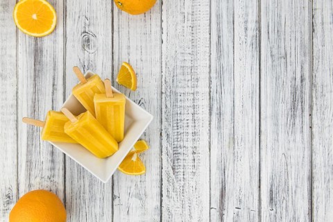 Some fresh made Popsicles (close-up shot, selective focus) on a wooden background