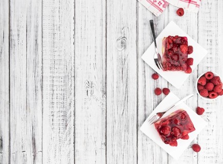 Fresh made portion of Raspberry Cake (selective focus, close-up shot) on rustic background