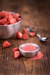 Strawberry powder as high detailed close-up shot on a vintage wooden table, selective focus