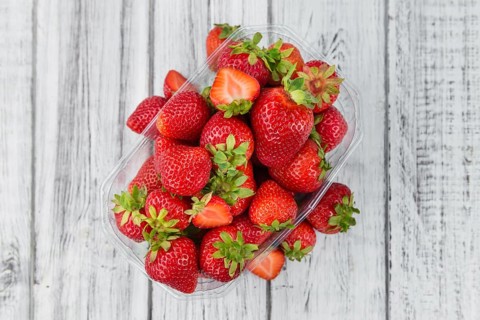 Strawberries as high detailed close-up shot on a vintage wooden table, selective focus