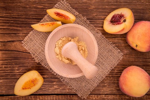 Peach powder on an old wooden table as detailed close-up shot, selective focus