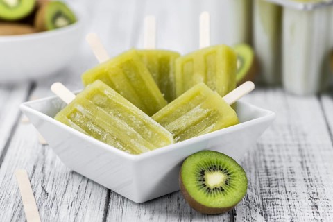 Some fresh Kiwi Popsicles on wooden background (selective focus, close-up shot)