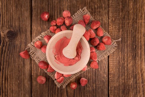 Strawberry powder as high detailed close-up shot on a vintage wooden table, selective focus