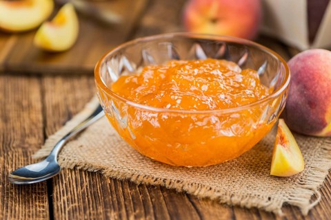 Portion of fresh Peach Jam close-up shot, selective focus